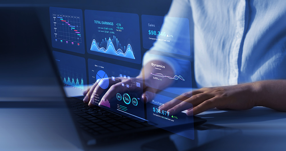 manos tecleando en un ordenador con visualizaciones de datos