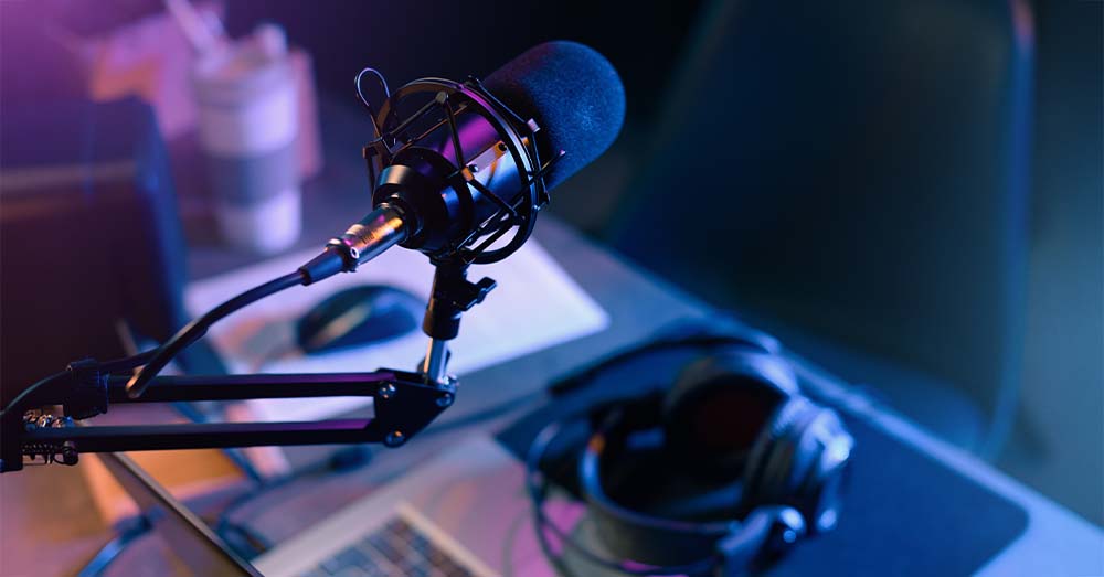 Un estudio de grabación de pódcast con un micrófono profesional en primer plano. 