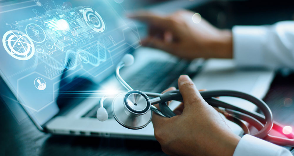 Profesional sanitario con un estetoscopio frente a un portátil con gráficos e iconos digitales de datos médicos superpuestos.