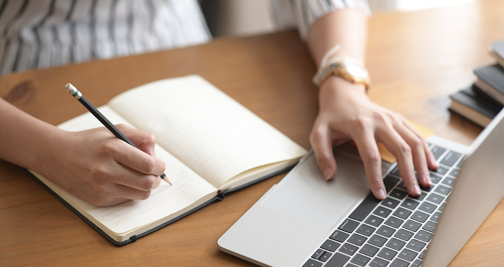 A person writing in a notebook.