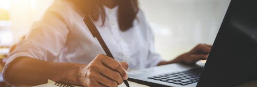 Una mujer escribiendo sobre un cuaderno