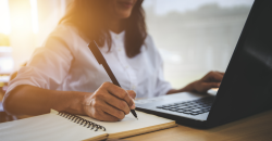 Una mujer escribiendo sobre un cuaderno